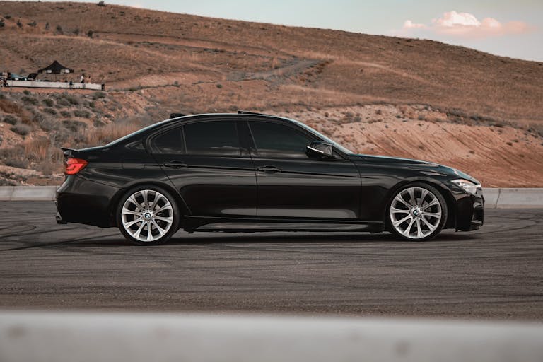A modern black sedan with tinted windows parked on a scenic hill in Türkiye.