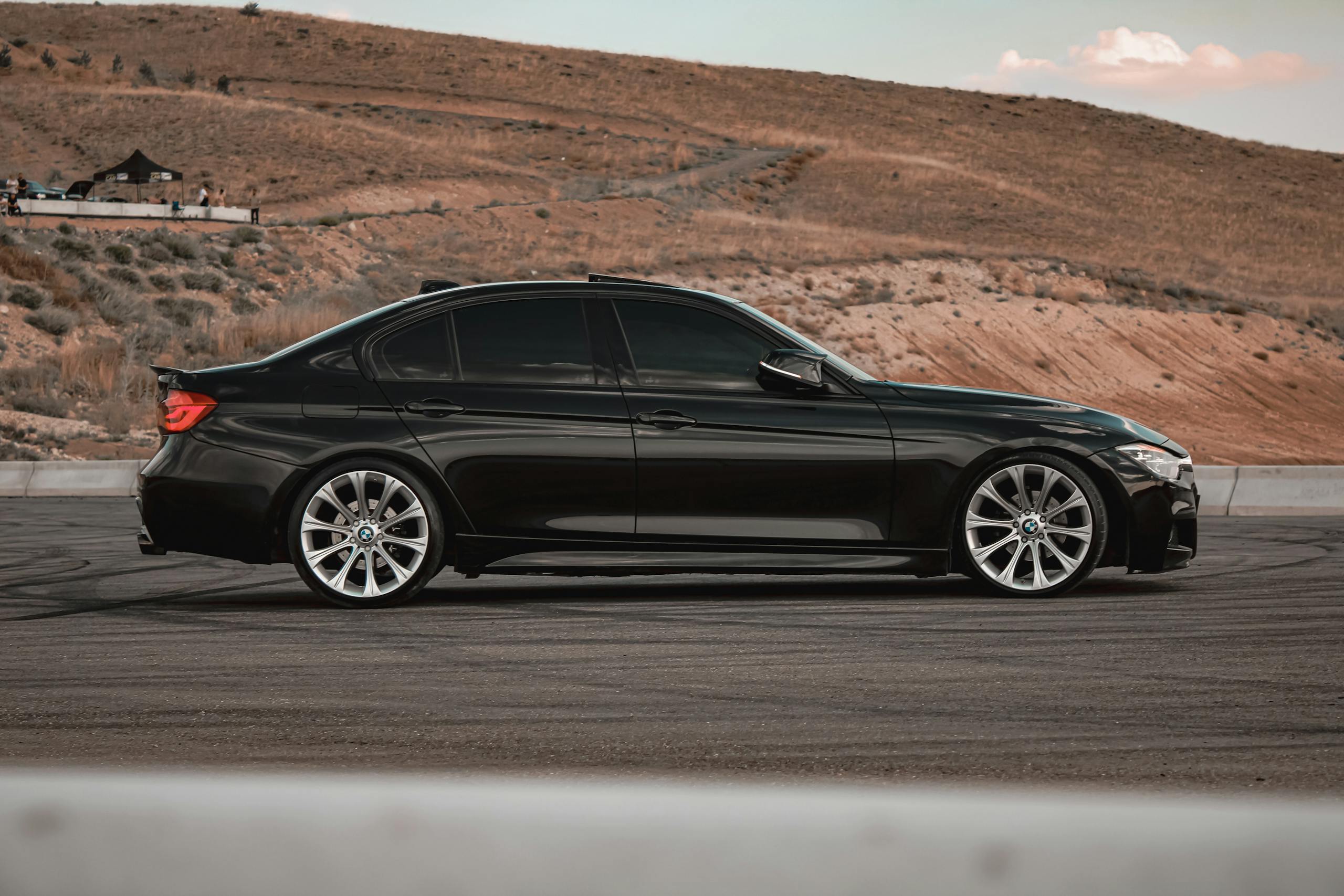 A modern black sedan with tinted windows parked on a scenic hill in Türkiye.