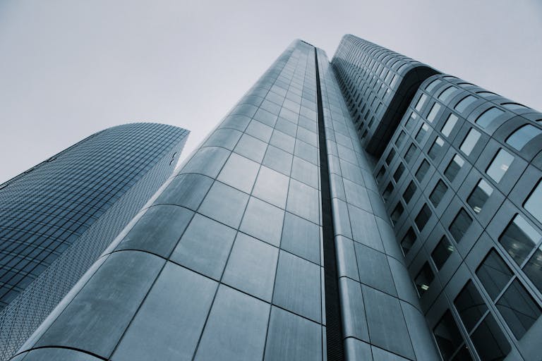 Low angle view of modern skyscrapers with glass and steel design. Perfect for corporate imagery.