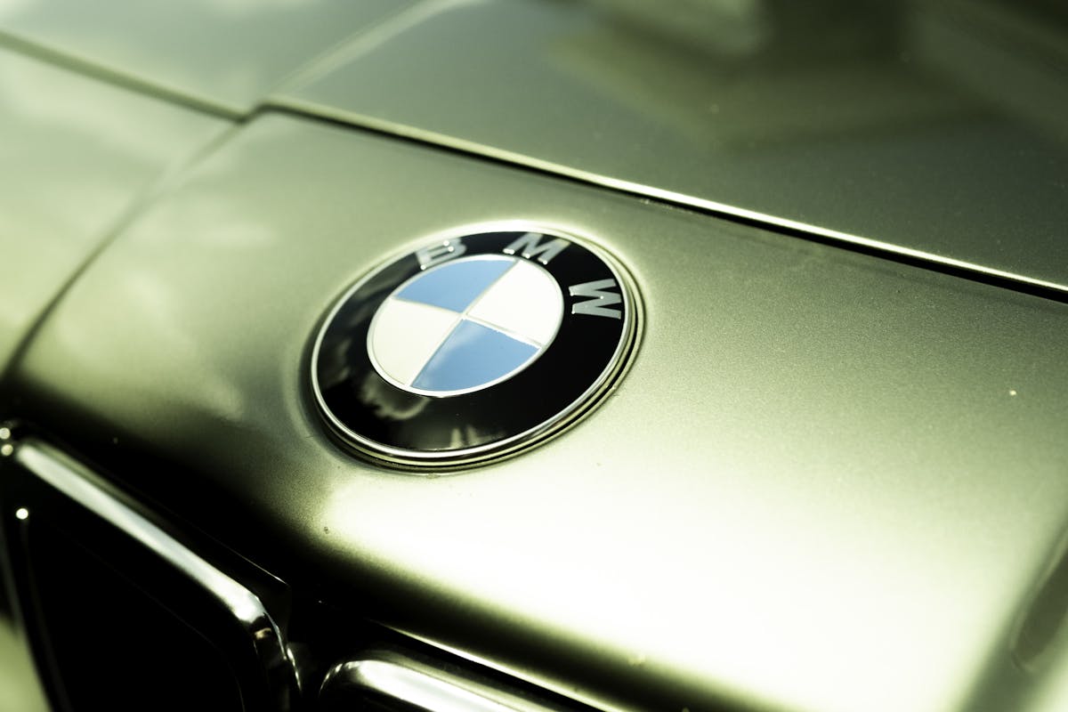 Sharp close-up of BMW logo on classic car hood, capturing its elegance and shine.