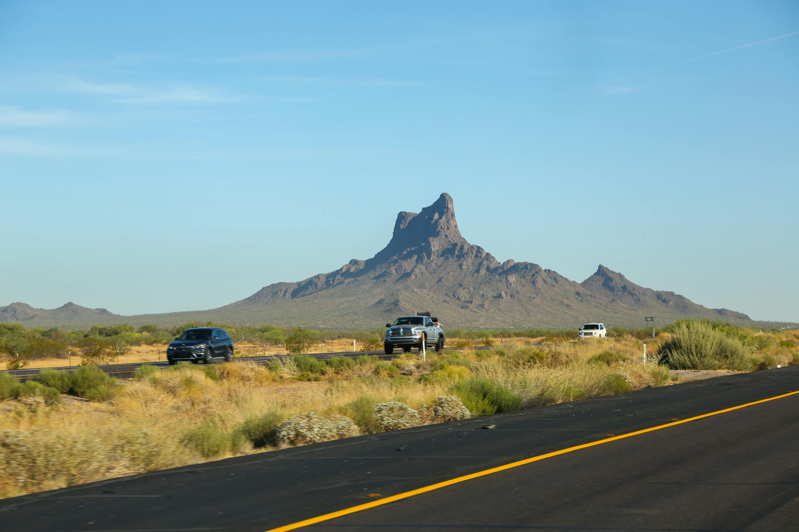 Tranquil highway drive through the desert with cars and mountain scenery.